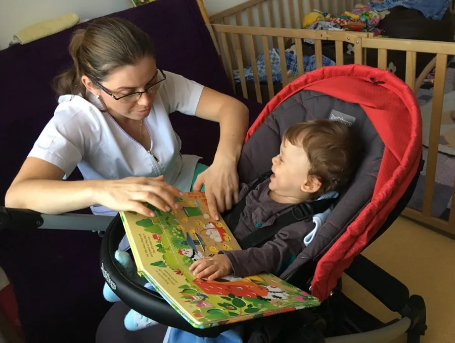 Ein Kind liest gemeinsam mit einer Pflegekraft im Hospiz
